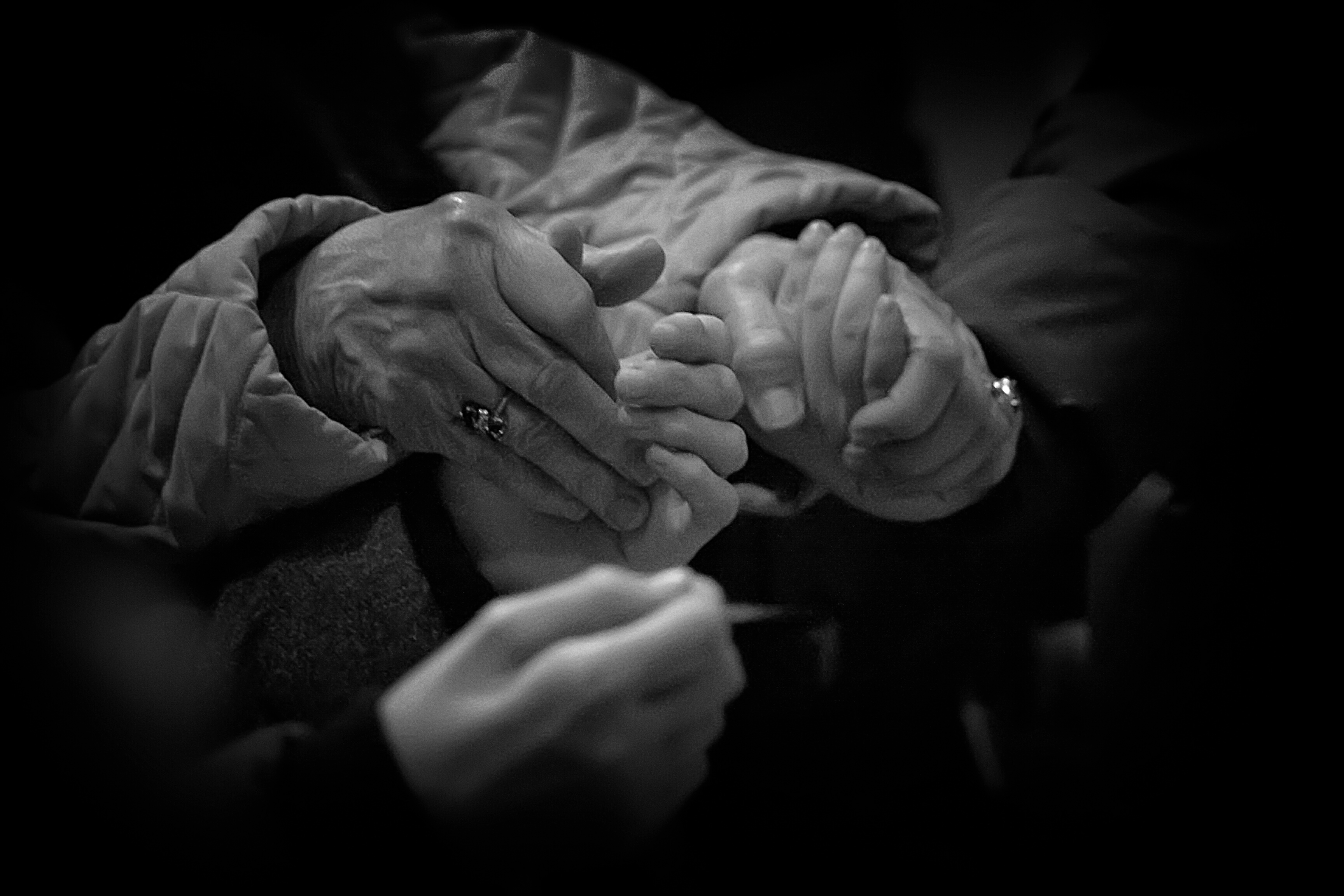 Close-Up Of People Praying By Holding Hands