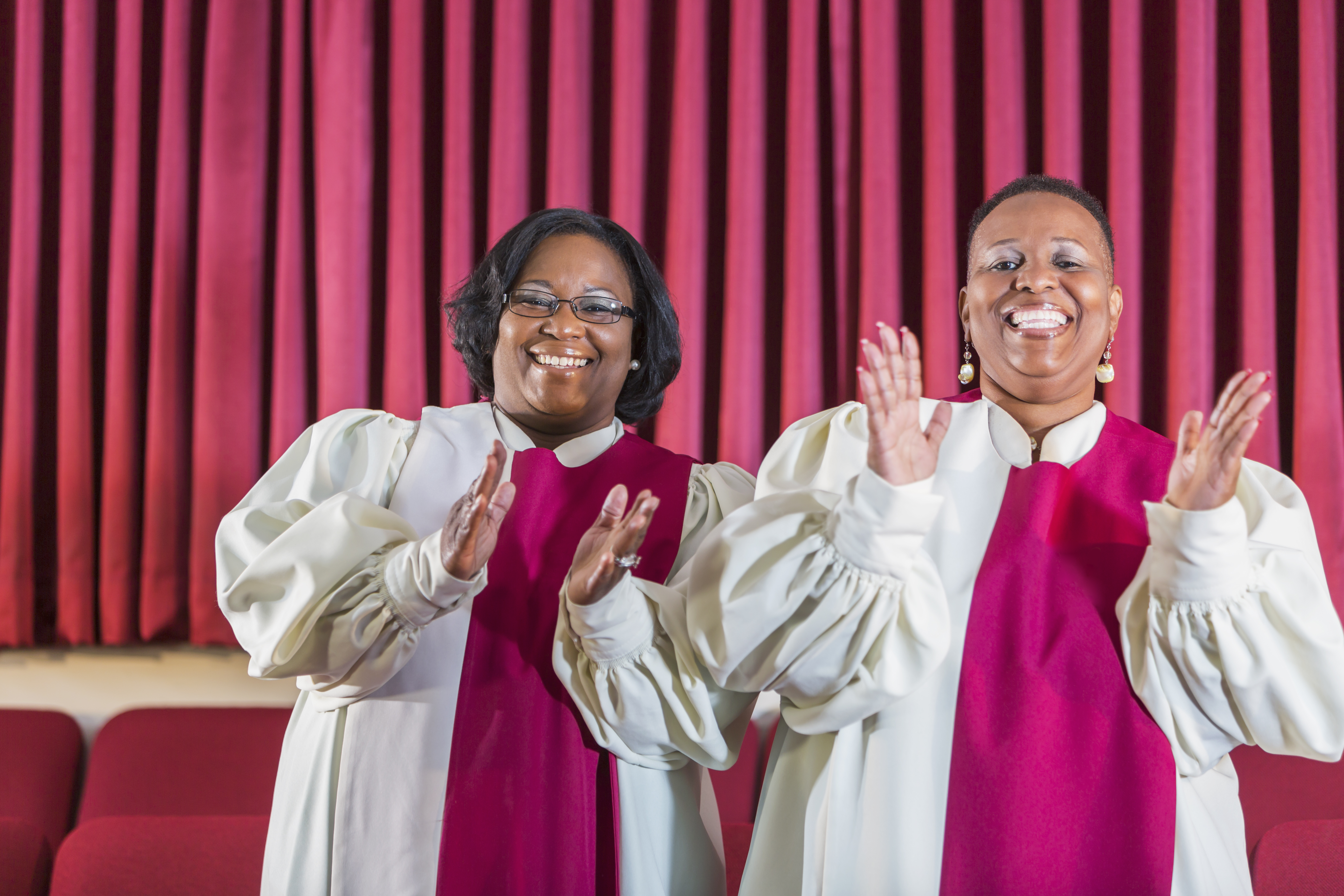 Two black women singing in church choir