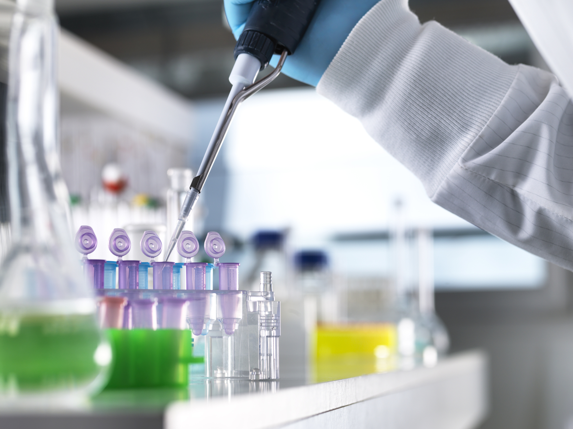 Scientist pipetting a sample into a vial for analytical testing in a chemistry laboratory.