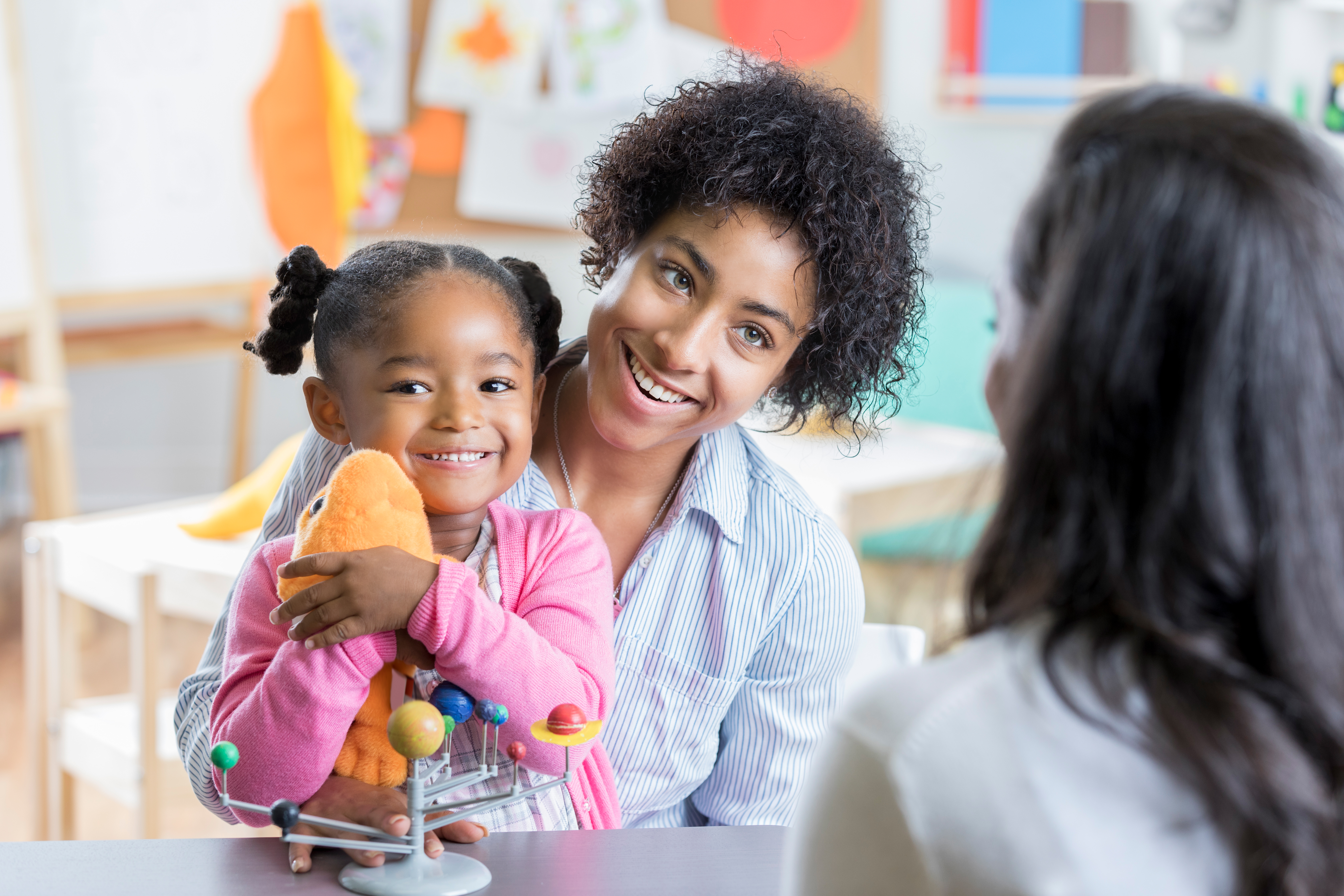 Little girl meets new preschool teacher with mom