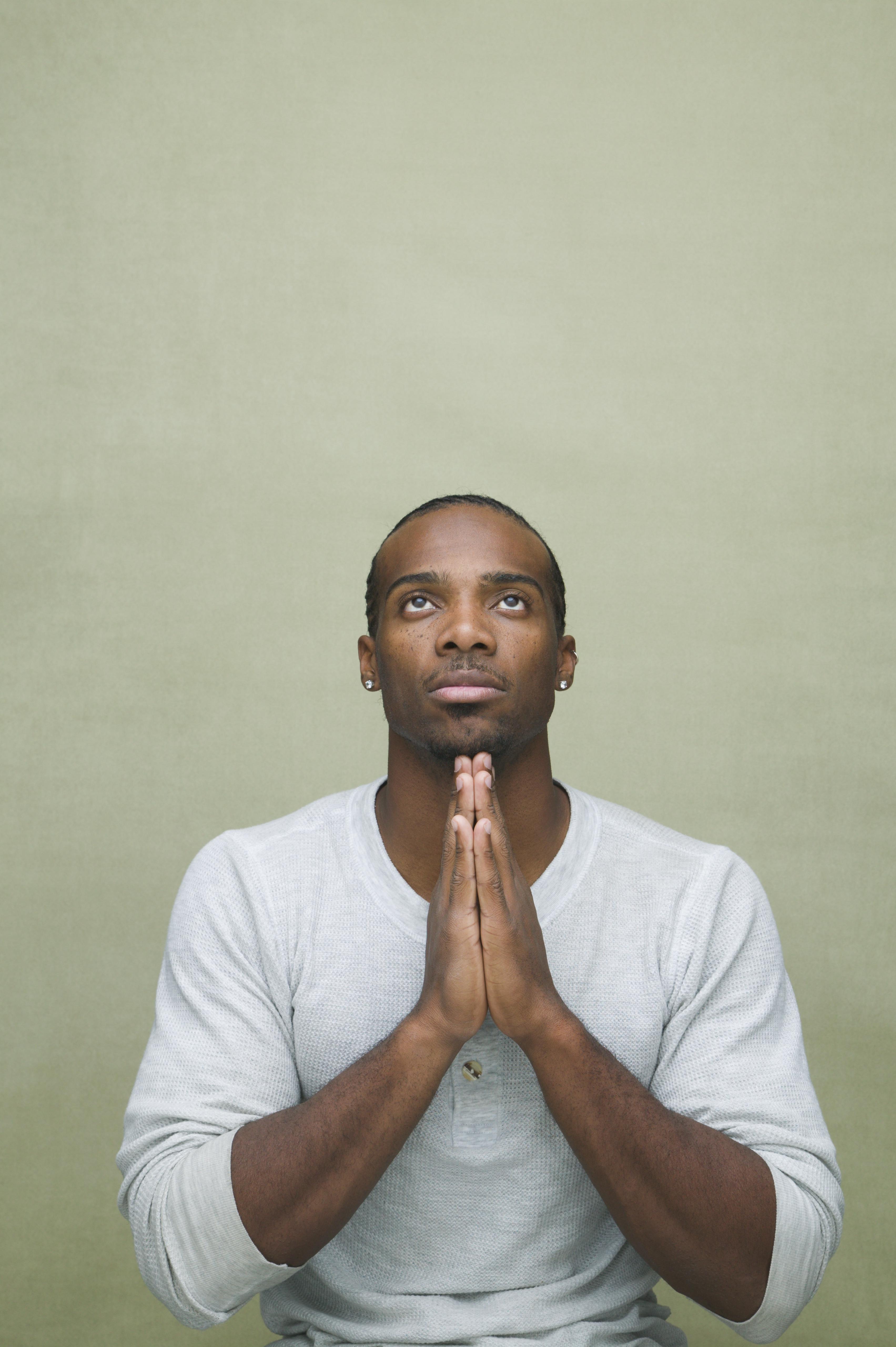Man facing forward with hands in prayer